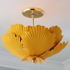 a yellow chandelier hanging from the ceiling in a room with white walls and ceilings