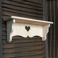 a shelf with a heart cut out on it's top and attached to the wall