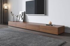 a flat screen tv sitting on top of a wooden entertainment center in a living room