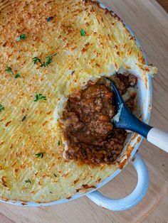 a casserole dish with meat and gravy in it on a wooden table