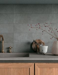 a kitchen counter top with a vase, sink and faucet next to it