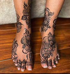 a woman's feet with henna tattoos on them