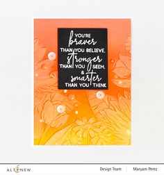 an orange and black card with words written on the front in white lettering, surrounded by flowers