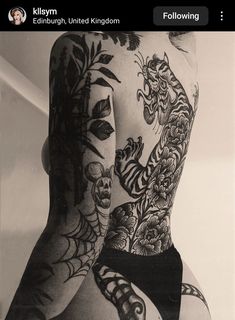 the back of a man with tattoos on his body