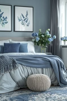 a bedroom with blue and white decor on the walls, bed linens and pillows