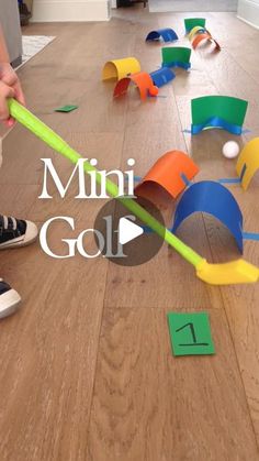 a child is playing with mini golf on the floor