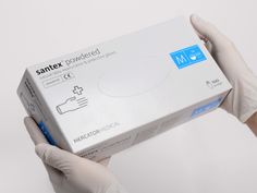 a person in white gloves holding up a box with the word santex printed on it