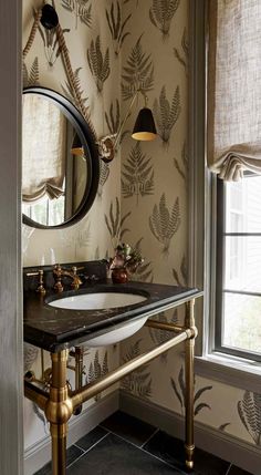 a bathroom with a sink and mirror next to a wallpapered wall in the corner