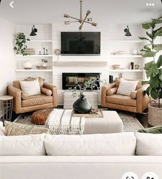 a living room filled with furniture and a flat screen tv mounted on the wall above a fire place