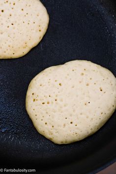 two pita breads frying in a skillet