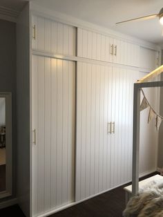 a bedroom with white closets and wooden floors