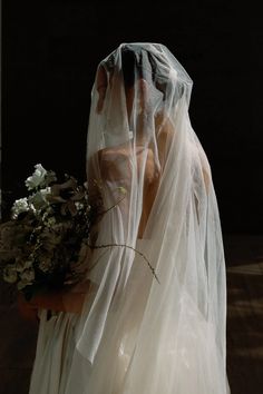 a woman wearing a veil and holding a bouquet