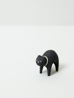 a small black bear figurine on a white surface