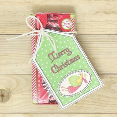 a christmas candy bag tied up on top of a wooden table with the tag hanging from it's side