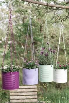 three hanging planters with flowers in them