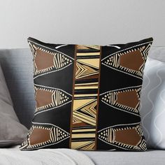 a black and gold throw pillow sitting on top of a couch