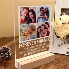 a wooden photo frame with four photos and flowers on the table next to it is a pine cone