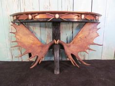 a wooden table with an intricate design on the top and two wings at the base