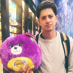 a man is holding a purple teddy bear