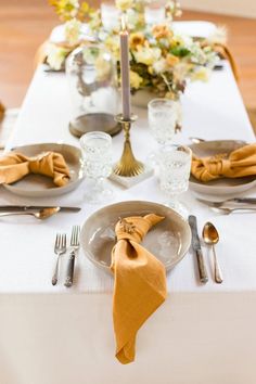 a white table topped with plates and silverware