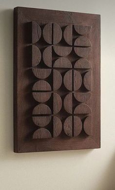 a wooden wall hanging on the side of a white wall