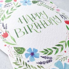 a happy birthday card with flowers and leaves