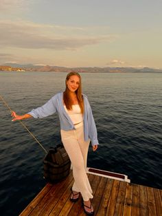 a woman standing on top of a wooden dock