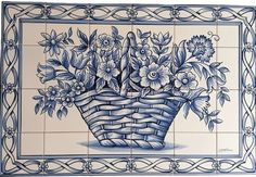 a blue and white tile with flowers in a basket