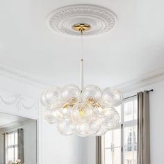 a dining room table and chairs with a chandelier hanging from the ceiling over it