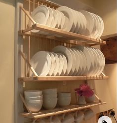 a shelf filled with white plates and bowls