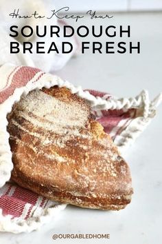 a loaf of sourdough bread sitting on top of a red and white towel