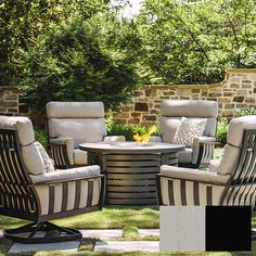 an outdoor patio furniture set with chairs, table and fire pit in the back yard