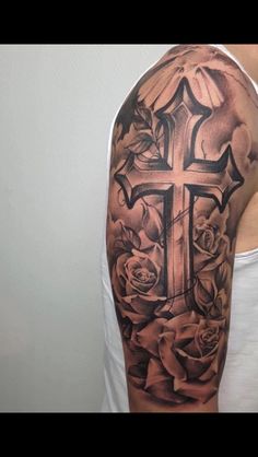 a man with a cross and roses tattoo on his arm