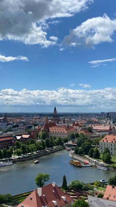 an aerial view of a river and buildings in the distance with blue skies above it