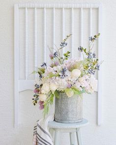 a vase with flowers sitting on top of a stool