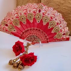 Wedding elegant and stunning Bridal hand held decorative luxurious red  fan ,bride ,mehndi ,maiyon, haldi wedding day shaadi walima accessory . Fixed open decorative fan hand embellished with crystals , ,beads ,acrylic decorative details ,hand embroidery  french knots and crystal encasing. Bejewelled with Zari golden flowers enhanced with teardrop diamanté . Handmade zari embellished organza  form the faux rose droplets which will hang as the fan is held.  These are exclusively made items and therefore will not be produced in large repetitive form making your wedding accessory unique. Taffeta silk cotton  woven fan base  ,printed and embossed and decorated with a medley of crystals  ,beads and finished with a sprinkle of glitter ,in hues of red and gold dimensions approx 41 cm x 46cm drop Bollywood Festive Bridal Accessories, Traditional Festive Bridal Accessories For Festivals, Traditional Bridal Accessories For Wedding, Traditional Festive Bridal Accessories, Bollywood Bridal Accessories With Pallu For Festivities, Festive Red Tikka With Zari Work, Red Kundan Tikka For Navratri, Red Tikka With Zari Work For Festive Occasions, Red Traditional Wear For Wedding Festival