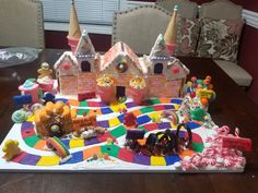 a table topped with lots of candy and candies next to a castle shaped cake