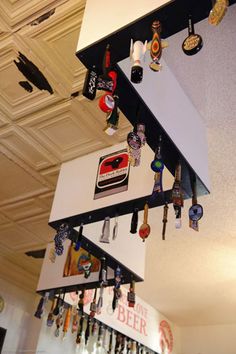 several beer bottles hanging from the ceiling in a room with many other items on it