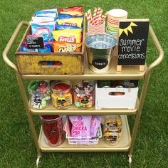 a cart filled with snacks and drinks on top of grass