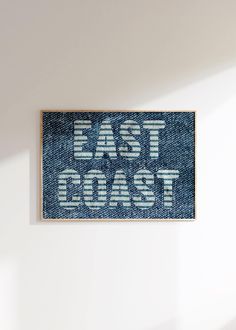 a blue and white sign that says east coast on the side of a wall in a room