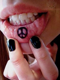 a woman with black nail polish and peace sign on her tongue