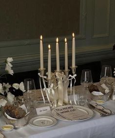 the table is set with white flowers and candles