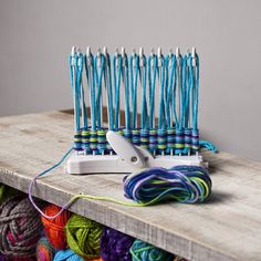 several skeins of yarn sitting on top of a wooden table next to a pair of scissors