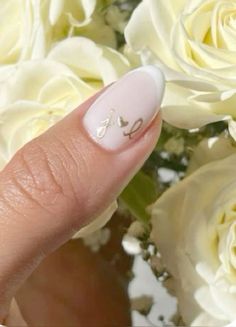 a woman's hand with white nail polish and flowers