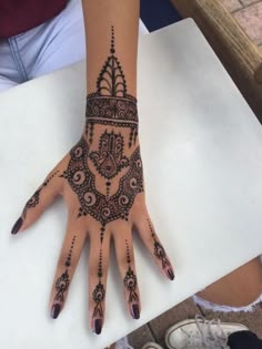 someones hand with henna tattoo on it