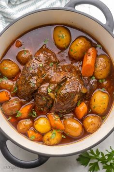 a pot filled with meat and potatoes on top of a table