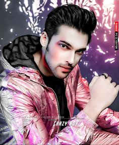 a man with black hair wearing a pink jacket and posing for a magazine cover photo