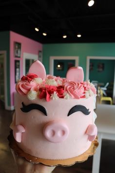 a hand holding a cake decorated like a pig