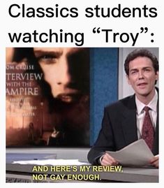 a man sitting at a desk in front of a monitor with the caption, classic students watching troy and here's my review not gay enough