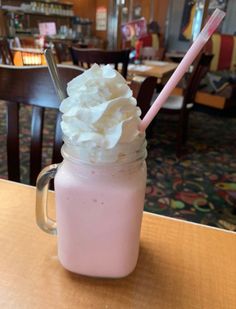 a pink drink with whipped cream on top and a straw sticking out of the cup